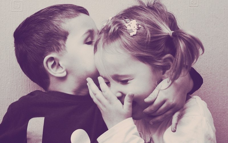 Девочка целует мальчика в щечку