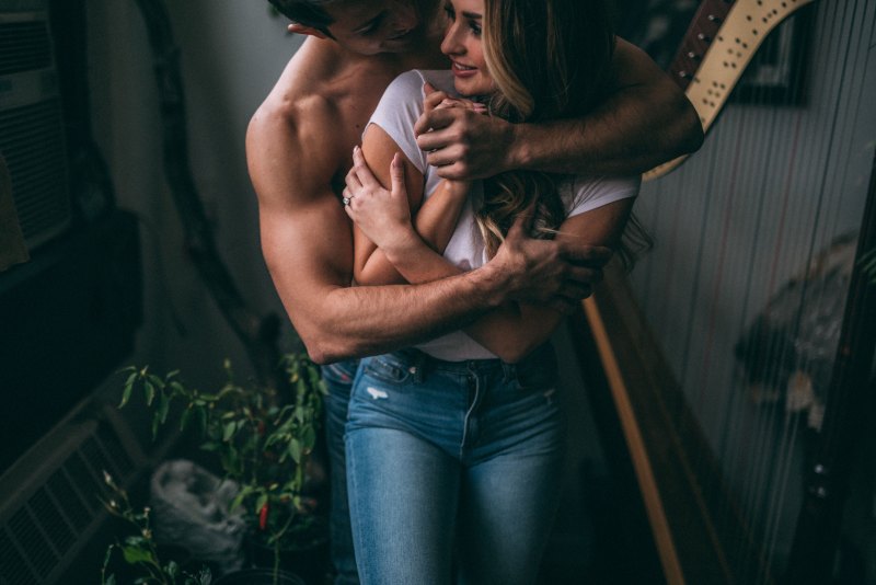 Обнимает девушку