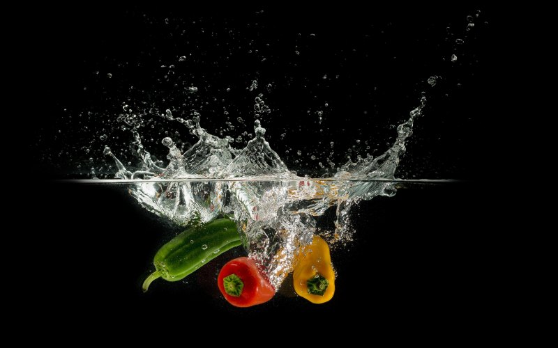 Фрукты в воде на черном фоне