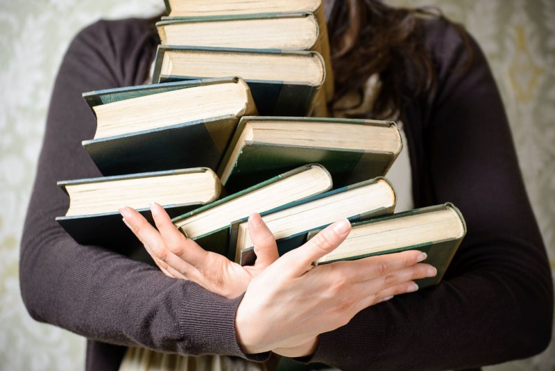 Много книг в руках